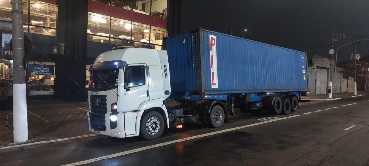 Caminhão com contêiner em operação noturna de transporte para importação e exportação